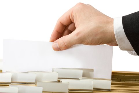 Ilustrační foto - Ruka úředníka s&nbsp;registračním formulářem