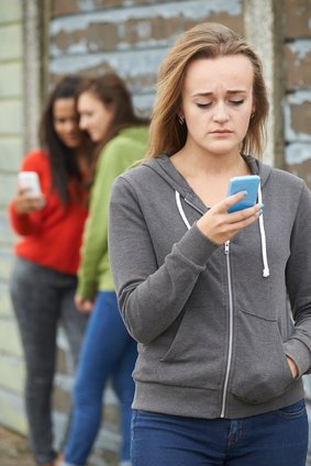 Smutná dívka hledí do mobilního telefonu Smutná dívka hledí do mobilního telefonu