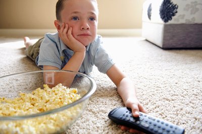 Dítě s popcornem před televizí Dítě s popcornem před televizí