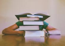 student schovaný za knihami