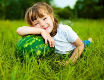 Dívka s melounem v trávě